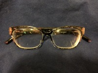 Dead glasses a pair of glasses, with large and visible scracthes on the left lens and crush damage on the left temple
